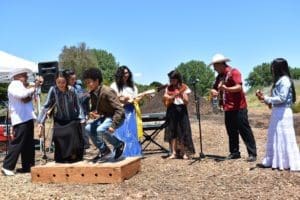 A group of musicians and dancers perform mexican folk music and dance outside